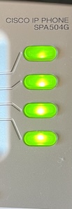 A photo of a Cisco 504G VoIP phone's line indicators, all are lit green.